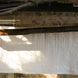 Serviette blanche accrochée à un linge-étendoir sous une terrasse en pierre en plein air.