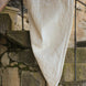 Serviette blanche délicatement drapée sur un balcon en pierre, motifs géométriques et reliefs visibles.
