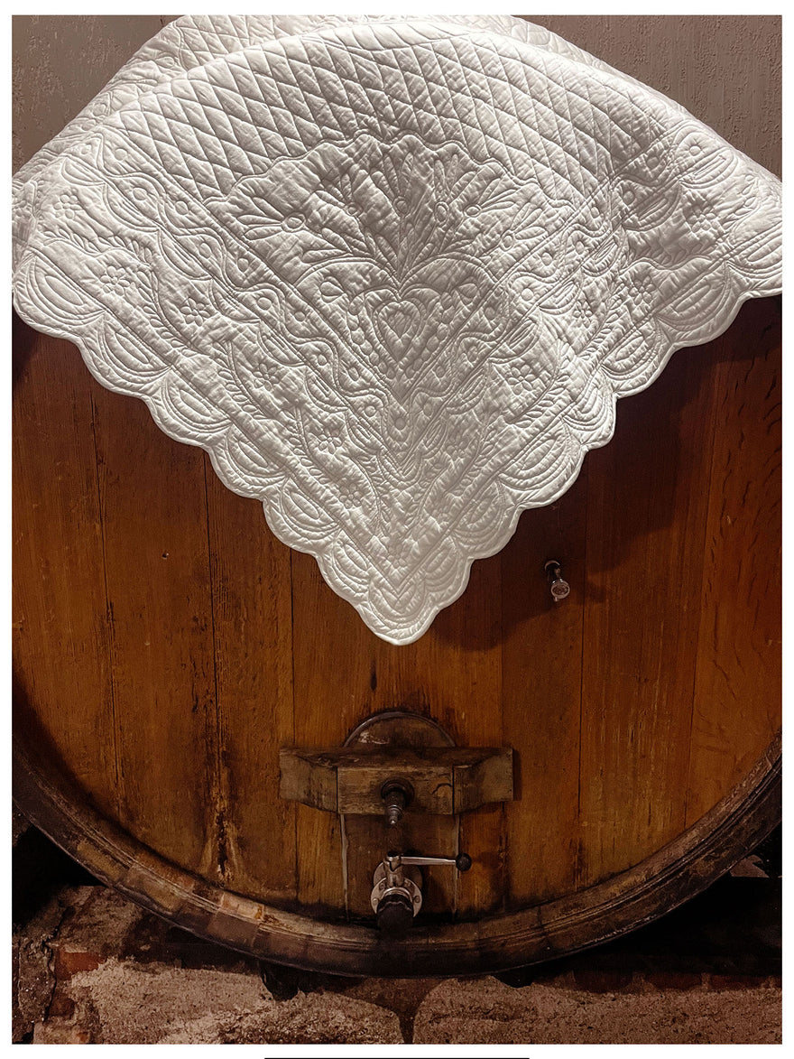 Le bord d’un voile orné posé sur un fût de barrique en bois, avec texte promotionnel « Le carré de mariage » et site petite-france.fr.