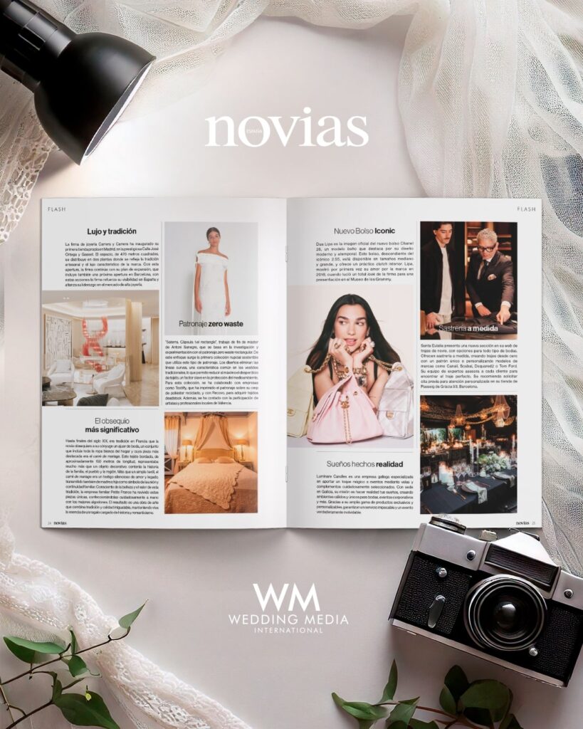 Magazine ouvert sur des pages de articles, posé sur tissu léger avec lampe noire et appareil photo vintage à droite. Motif "novias" en haut. WM Wedding Media en bas.