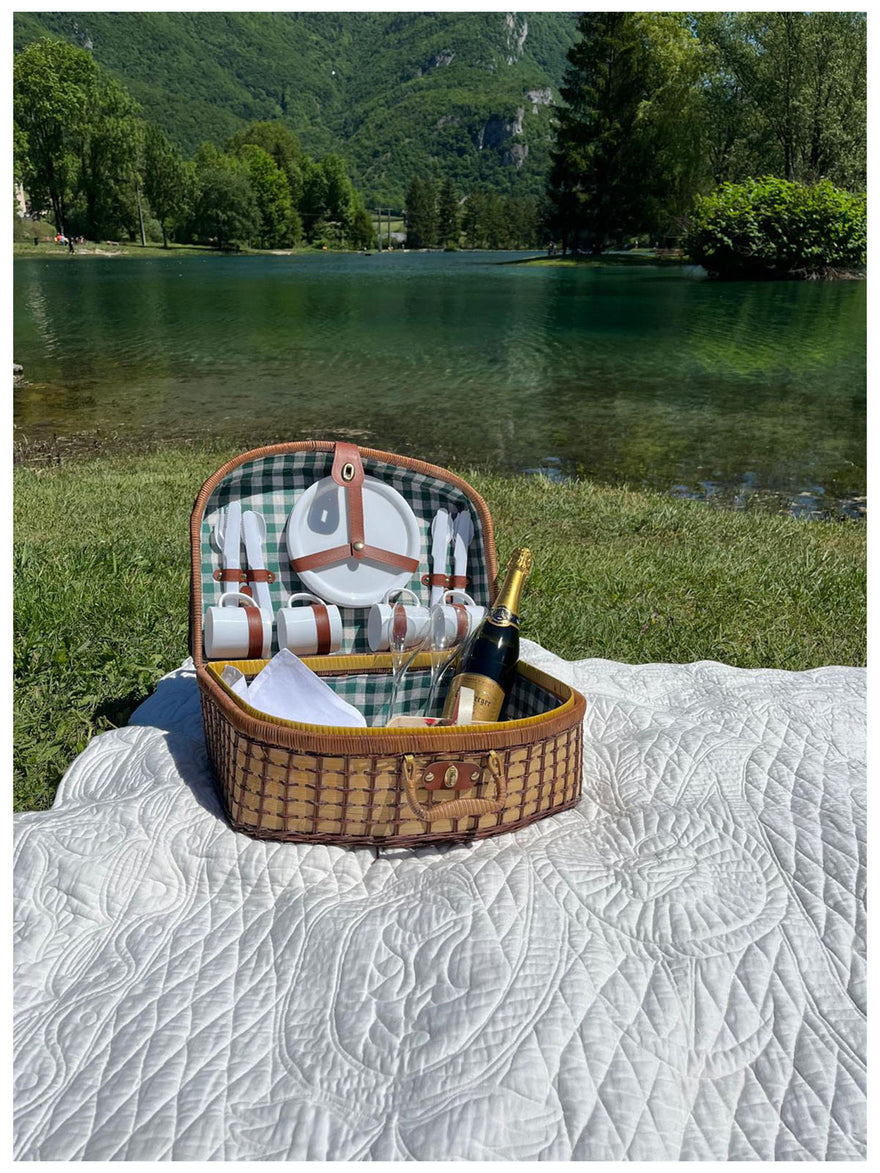 Panier pique-nique en osier ouvert sur une couverture, bouteille de champagne et vaisselle, au bord d’un lac verdoyant. Le texte “Le carré de mariage Petite France” apparaît en haut.
