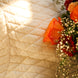 Bouquet de fleurs coloré (roses, baby’s breath, chrysanthèmes) posé sur une couverture crème à motifs, ensoleillé.