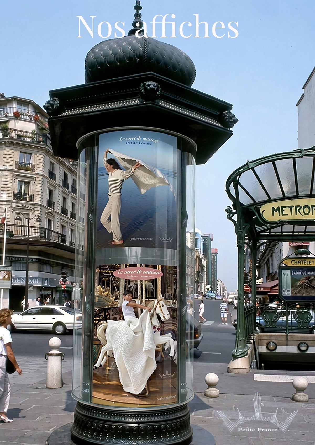 Publicité lumineuse dans une colonne publicitaire vitrée au milieu d’une rue urbaine, avec un chevalet et une mariée en cape blanche.